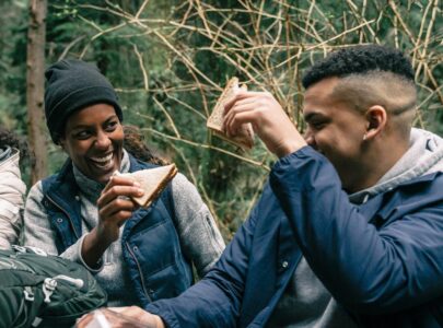 Man and woman eating sandwich outdoors